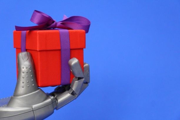 机器人手拿礼物：机器人祝贺概念图片下载