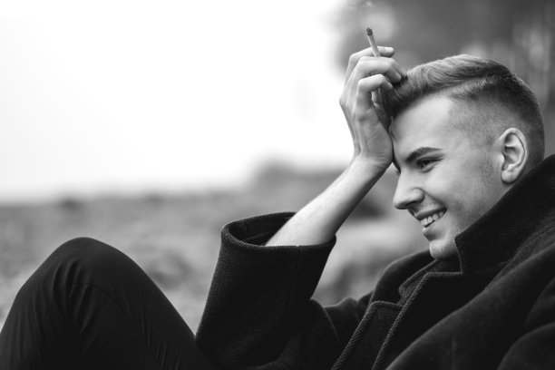 帅气的男人穿着外套抽着烟，艺术人像的男人，黑白照片图片下载