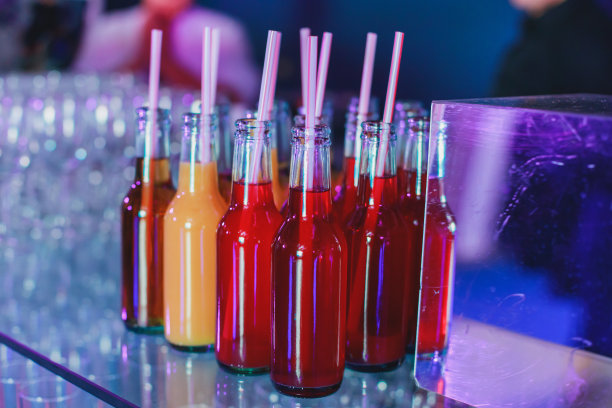 酒席上的酒席布置，一排排不同颜色的酒精鸡尾酒放在宴会上，马提尼、伏特加等酒席上装饰花束图片下载