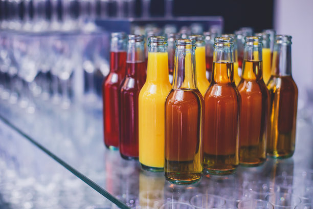 酒席上的酒席布置，一排排不同颜色的酒精鸡尾酒放在宴会上，马提尼、伏特加等酒席上装饰花束图片下载