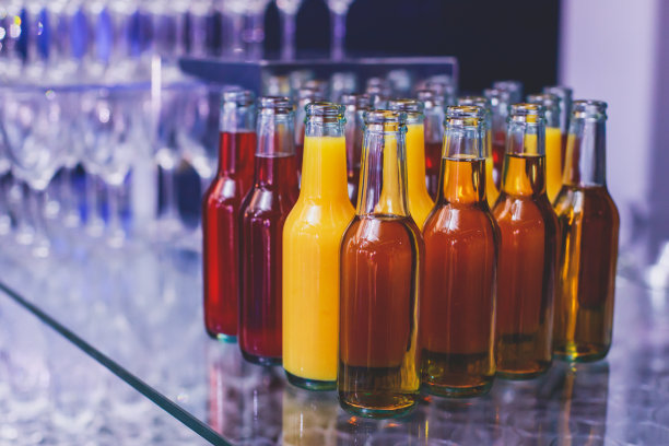 酒席上的酒席布置，一排排不同颜色的酒精鸡尾酒放在宴会上，马提尼、伏特加等酒席上装饰花束图片下载