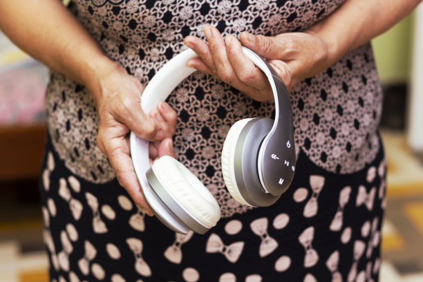 阿拉伯成熟女性穿着连衣裙，手持无线耳机。图片下载