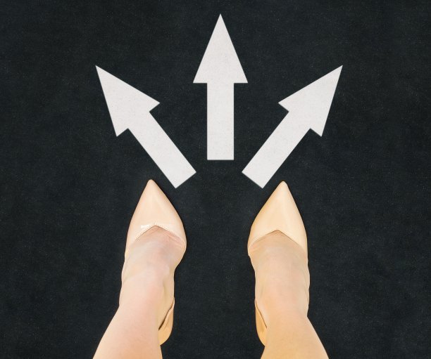 女人在高跟鞋站在柏油路与三方式箭头概念图片下载