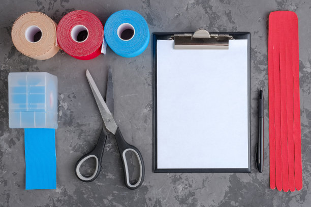 滚动运动机能学磁带为运动员，剪刀和剪贴板与笔在白色背景，俯视图。图片下载