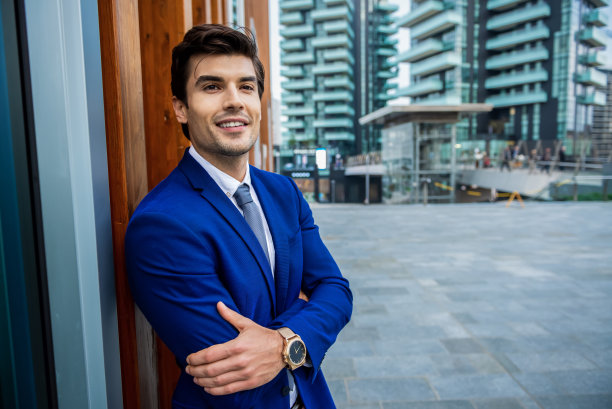 一个西装革履的商人站在建筑物前的肖像图片下载