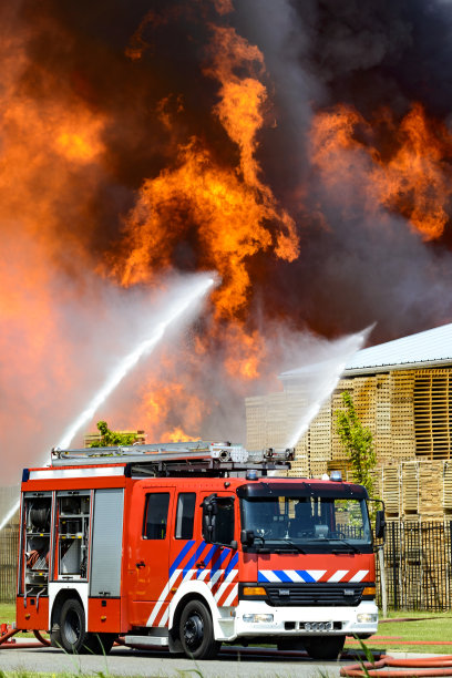 一辆消防车在一场大火前的一个工厂在工业区图片下载