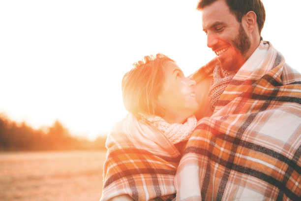 一对深情的情侣在户外裹着毯子图片下载