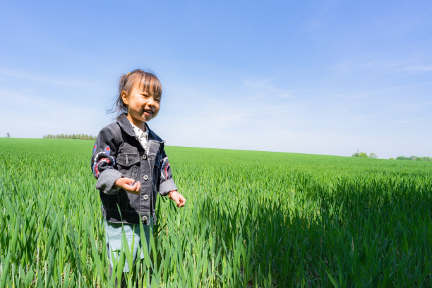 草丛中一个微笑的小女孩图片下载