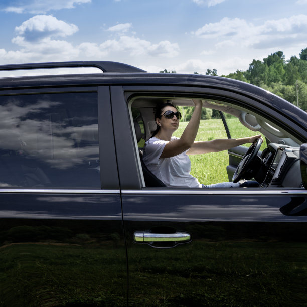 坐在方向盘后面的女人打开了她车里的舱门图片下载