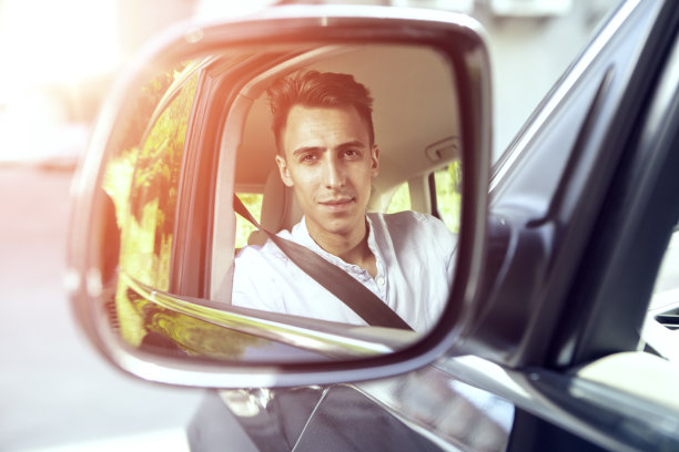 年轻漂亮的商人在车里。后视镜里的映像图片下载