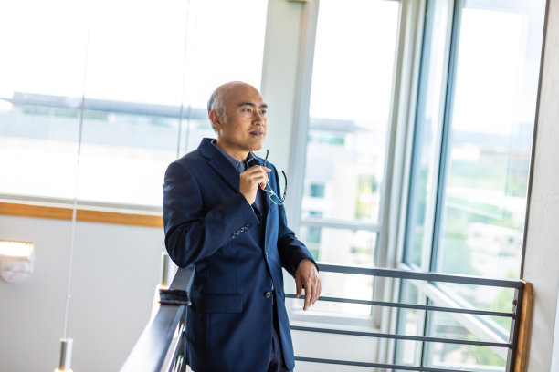 成熟的成年男性中国商人在城市现代办公空间使用移动通信和计算技术系列图片下载