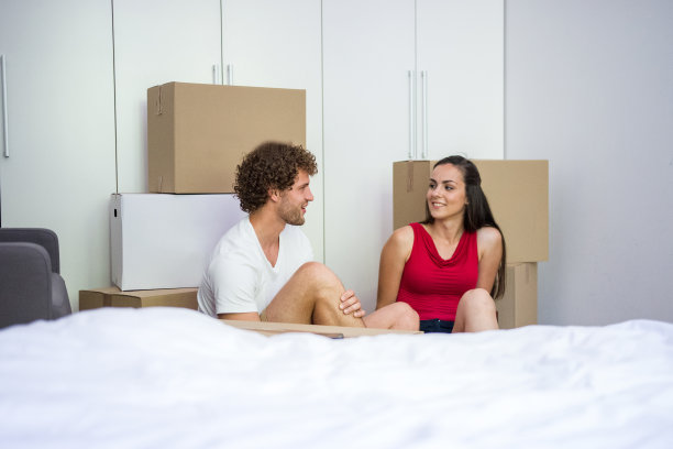 一对年轻的异性恋夫妇坐在新房子的地板上聊天图片下载