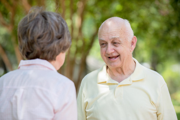 快乐的老男人微笑着与老女人在户外交谈图片下载