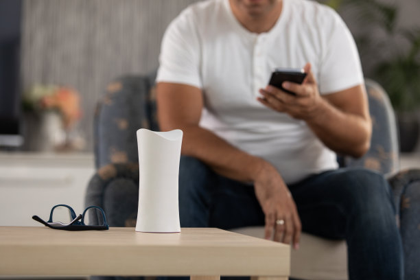 桌子上有智能设备，男人在家里用手机图片下载