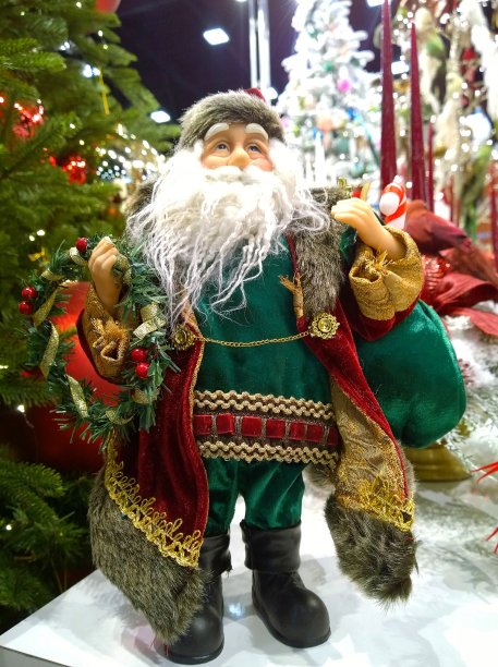 玩具圣诞老人和礼物。模糊的背景中装饰着闪亮的圣诞树。传统的圣诞装饰品和收集的节日装饰。恭贺新禧。冬天的装饰品。图片下载