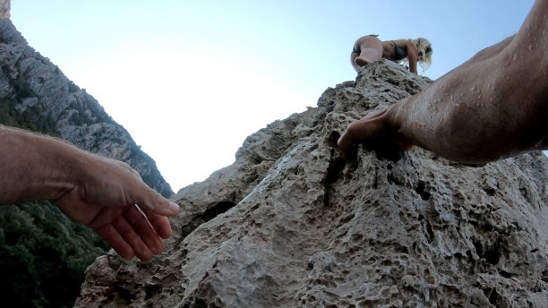 男人的手爬上海边的悬崖图片下载