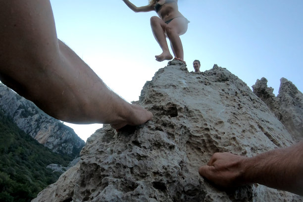 男人的手爬上海边的悬崖图片下载