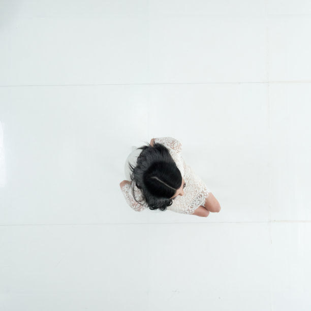 一个人/全身/直接俯瞰/鸟瞰图20-29岁的成年人美丽的黑发/长头发高加索女性/年轻女性坐在/休息在白色背景穿着裙子/凉爽的态度图片下载