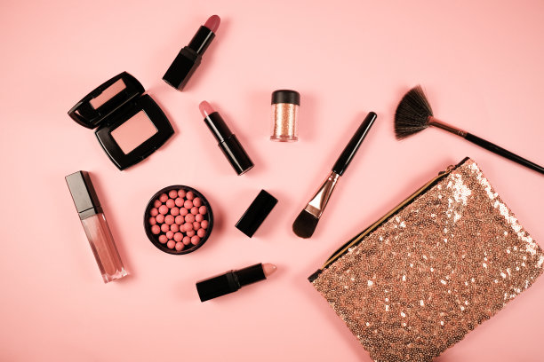 化妆包与美容产品在粉红色的背景。女人的魅力。图片下载