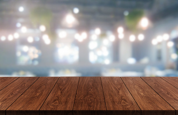 现代餐厅或咖啡店模糊背景下的木桌，桌子上的空白空间用于产品展示模型。图片下载