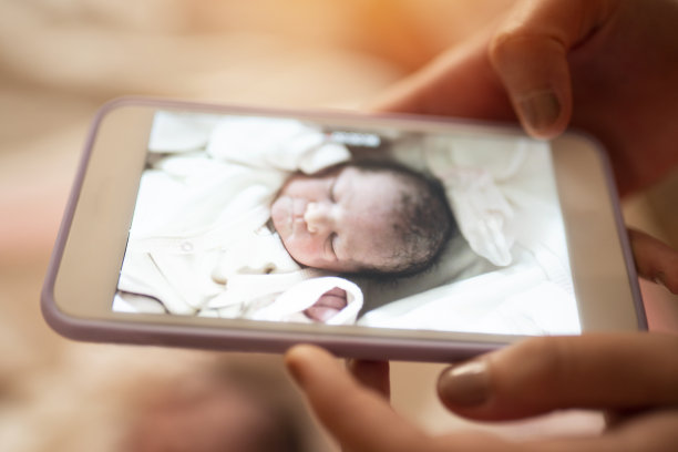 妈妈在给刚出生的宝宝拍照图片下载