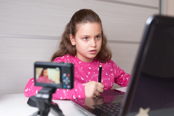 年轻的数字艺术家女孩在平板电脑上画画的时候做视频。图片下载