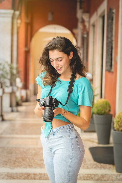 女游客或专业摄影师在一个典型的意大利城市拍摄。图片下载