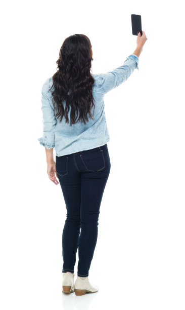 全长/后视图/背面/一个人的成年漂亮的棕色头发/长发白种人女性/年轻女性/中年成年女性/中年照片穿着纽扣衬衫/衬衫/牛仔裤/裤子和拿着手机图片下载