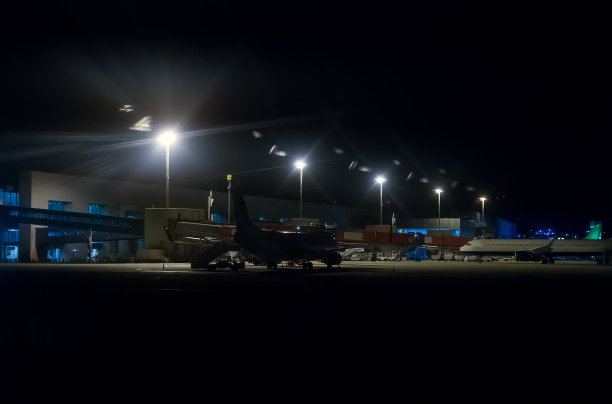 夜间机场机库附近的客机。图片下载