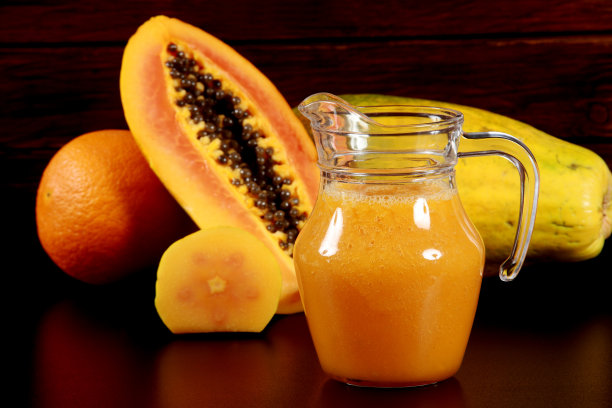 新鲜成熟木瓜的果汁和甜点在木材背景图片下载