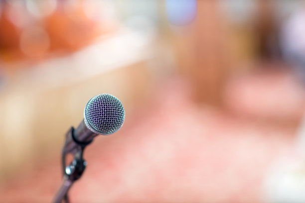 在音乐厅或会议室的麦克风柔和和模糊风格的背景。麦克风上方是会场或会议室背景的抽象模糊照片。图片下载