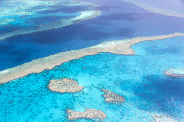 鸟瞰图在海道通过大堡礁附近的airlie海滩被浅海珊瑚礁包围在蓝绿色清澈的水。图片下载