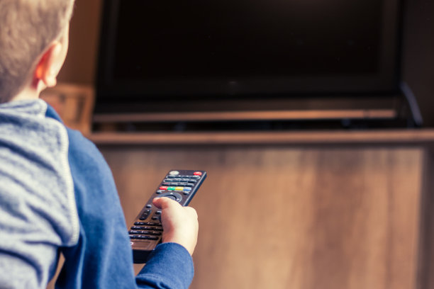 小孩用遥控器换频道的特写。图片下载