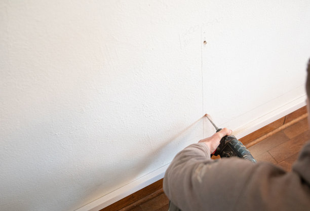 水管工在住宅内墙钻孔图片下载