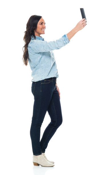 全长/侧视图/侧面视图/一个成年人美丽的棕色头发/长发白种人女性/年轻女性/中年成年女性/中年人照片穿着纽扣衬衫/衬衫/牛仔裤/裤子和拿着手机图片下载