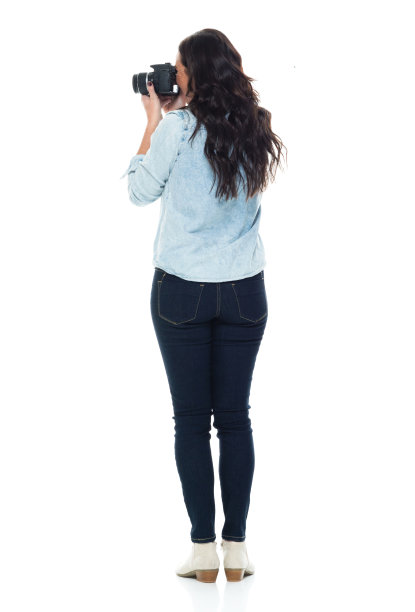 全长/后视图/后面/一个成年人漂亮的棕色头发/长发白种人女性/年轻女性/中年成年女性/中年摄影师/摄影/游客站在纽扣衬衫/衬衫/牛仔裤/裤子图片下载