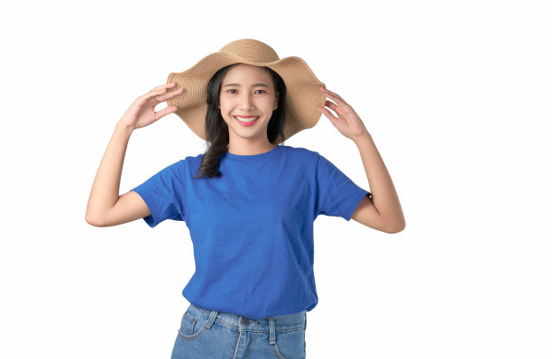 迷人的年轻亚洲女子站在触摸帽子的头上，感到幸福的白色背景。图片下载