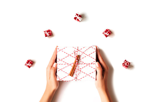 女人的手拿着礼盒在白色的背景。图片下载