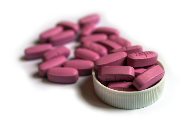 粉红色药片堆在白色的背景，孤立图片下载