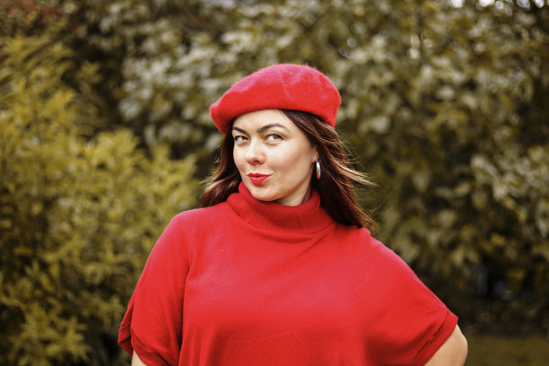 肖像时尚美丽的年轻女子在明亮的红色帽子和毛衣与红色的嘴唇看着相机。秋天的生活方式。图片下载