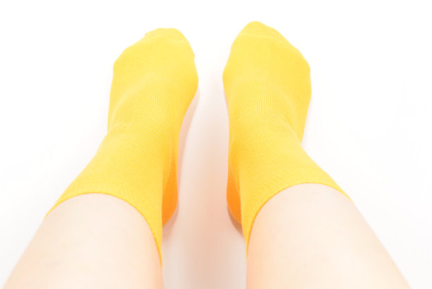 黄色袜子上的女人脚孤立在白色的背景。图片下载