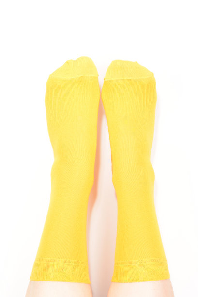 黄色袜子上的女人脚孤立在白色的背景。图片下载