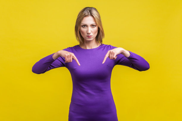 此时此地。专横的女商人手指向下的肖像。孤立在黄色背景上图片下载