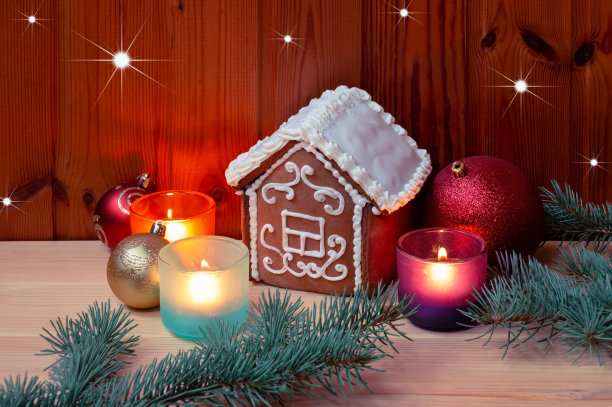 桌上放着圣诞球和蜡烛，点缀着釉料的小姜饼屋。图片下载