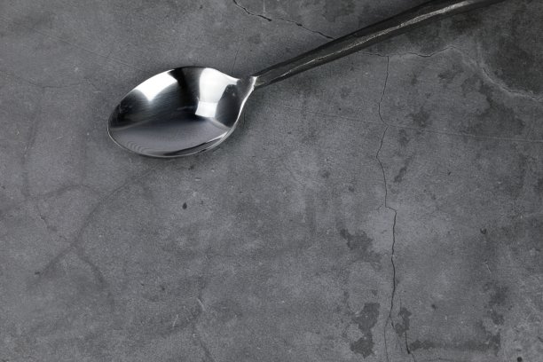灰色混凝土背景下的铁勺图片下载