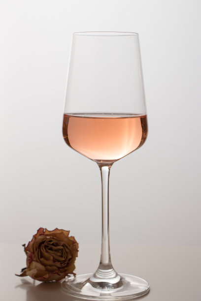 酒杯里的玫瑰酒配上白色的背景，浪漫典雅的葡萄酒照片配上复制空间图片下载