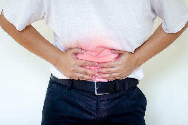 家中病人胃痛，双手挤压腹部。医疗保健的概念。图片下载