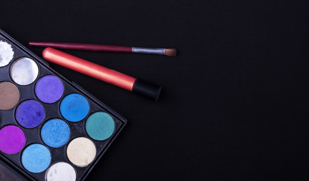 眼影调色板与刷子和口红在黑色纹理的背景图片下载