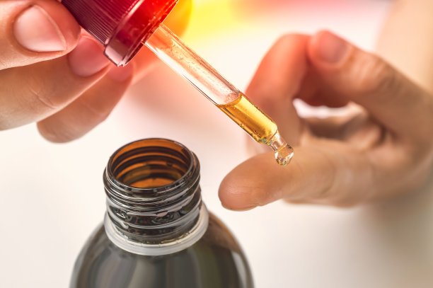 脸部胶原蛋白血清滴在女性手指上图片下载