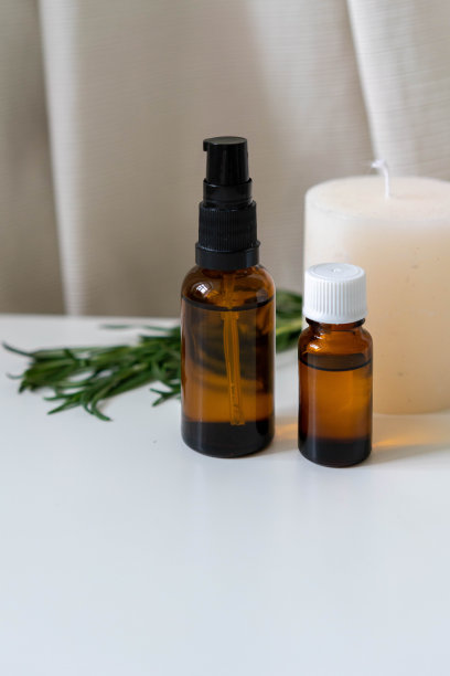 香熏照片与迷迭香药草，精油在瓶子和香薰蜡烛。垂直方向。图片下载